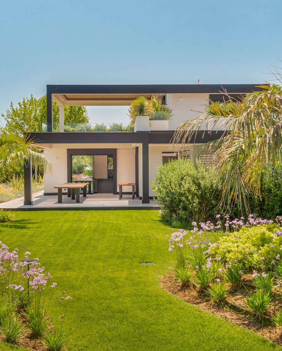 Il giardino della villa con pergolato e vegetazione mediterranea